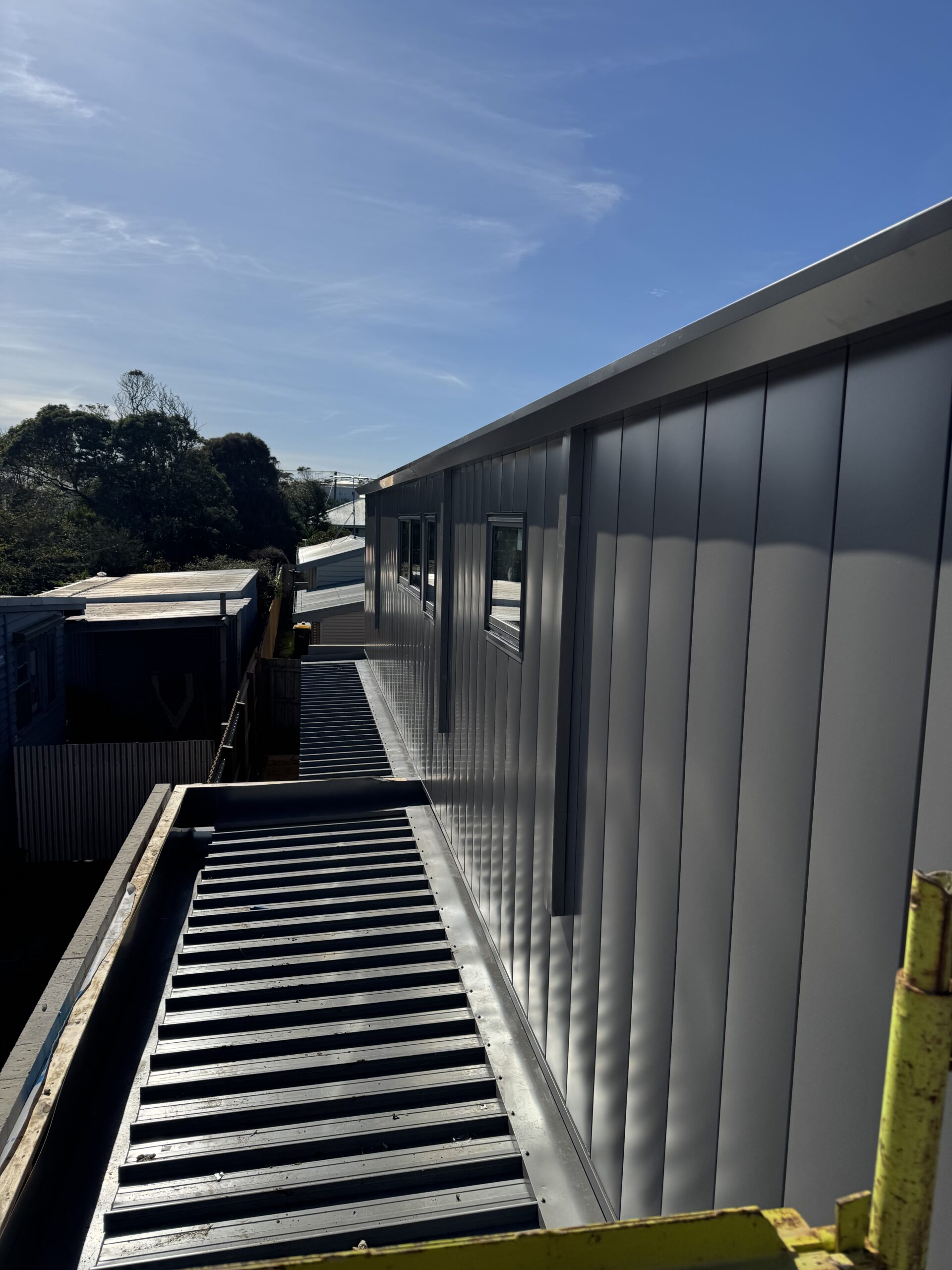 Architectural interlocking metal wall cladding in Colorbond Wallaby installed on a coastal home in Torquay Victoria