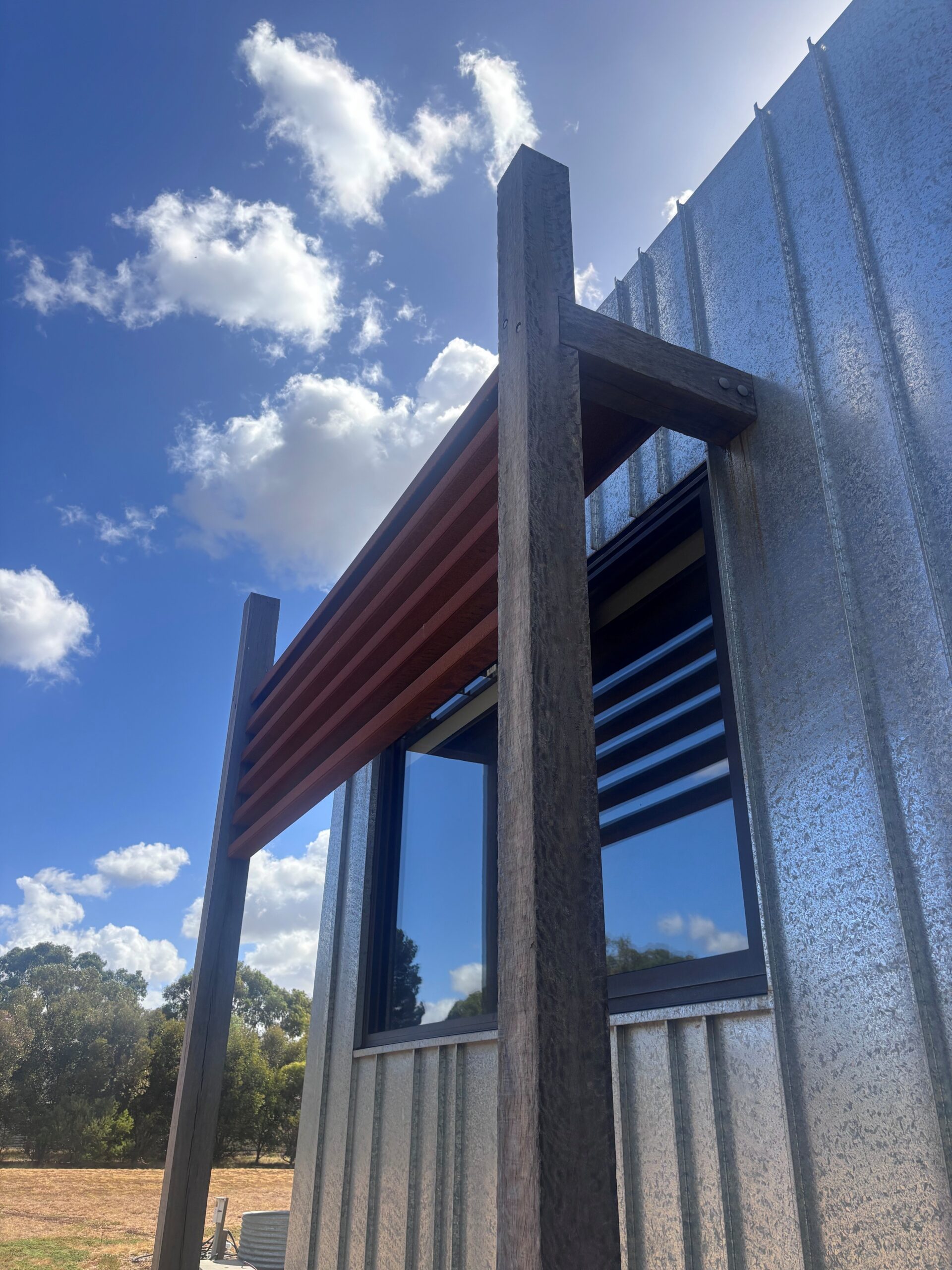 Galvanised standing seam wall cladding with timber detailing on a Geelong home